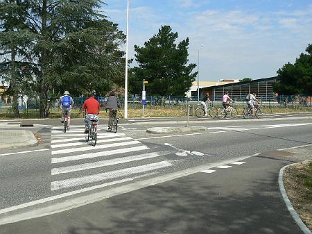 P1070609.JPG - Quand la piste traverse la chaussée pour longer le CEAT, les véhiculent l'identifient mal : le symbole vélo n'est pas facilement interprétable derrière les bandes du passage piéton. Un peu de vert aurait été nécessaire.