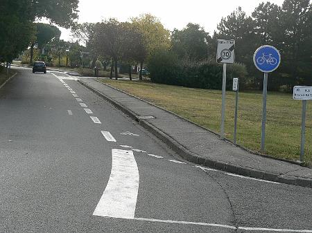 P1090049.JPG - Sortie de la zone 30 du coeur de ville. Erreur sur le panneau de piste cyclable (rond au lieu de carré). La marque au sol du stop devrait être en retrait de la piste cyclable.